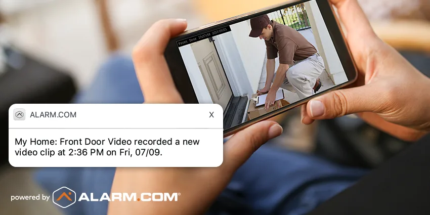 Phone showing a front door video clip of a package delivery, with an alert from the app
