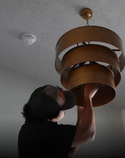 C&C electrician installing a ceiling light fixture